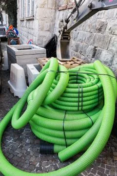 Roll of plastic pipe for road works. Protection of electric or telephone cabl Stock Photos
