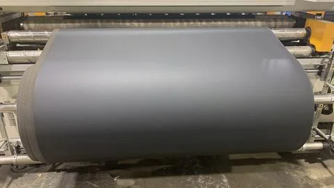 Roll PVC Black Leather at the machine. Industry manufacturing Stock Photos