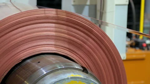 Roll of red copper sheet is unwound in the machine close-up Stockbeeldmateriaal 103848671