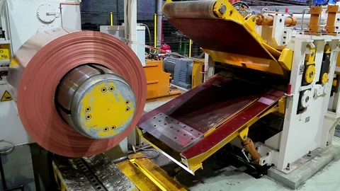 The roll of red copper sheet is unwound in the machine Stock Footage 103849042