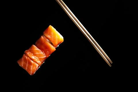 Roll with red fish isolate on a black background 库存照片