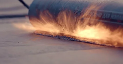 The roll of ruberoid is melted by the flame of a gas burner Stock Footage 119625678