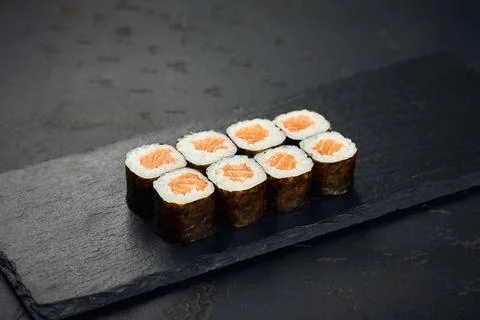 Roll with salmon on dark background. Sushi menu. Japanese food. Stock Photos