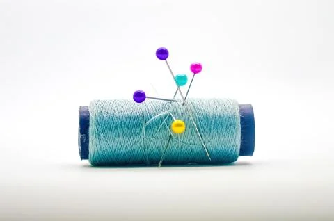 A roll of sewing thread pierced by a pin isolated on white background with .. Stock Photos