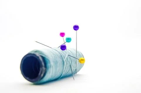 A roll of sewing thread pierced by a pin isolated on white background with .. Stock Photos