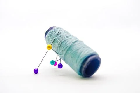 A roll of sewing thread pierced by a pin isolated on white background with .. Stock Photos
