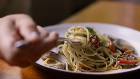 Roll the spaghetti on a fork and greedily eat pasta with vongole, long spaghetti Stock Footage 256156738