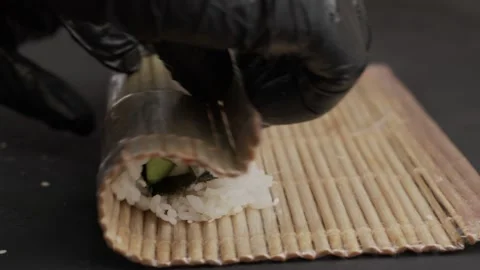 Roll the stuffed rice into a ready-made sushi roll. Sushi cooking. Black wood ba Video stock 145343364