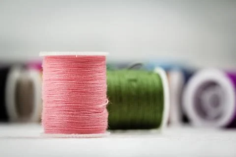 The roll of thread on background,show texture of soft pink color thread,needl Foto stock