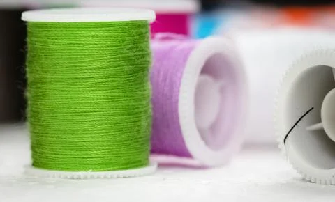 The roll of thread put at the left side on background,green thread,needlework Foto stock