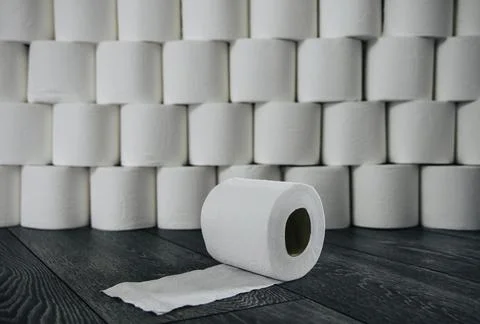 Roll of toilet paper in front of a stack of toilet rolls Stock Photos