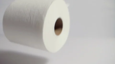 Roll of toilet paper lands dramatically in frame on white background Vídeos de archivo 126571389
