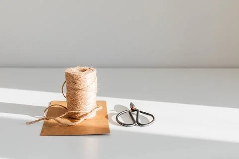 Roll of twine with black scissors for packaging 스톡 사진