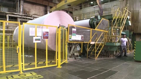 A roll of white paper comes out of a paper making machine. Paper production Video stock 267401251