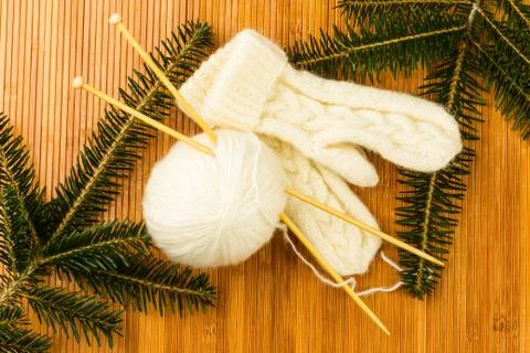 Roll of white soft knitting yarn and knitting mittens Stock Photos