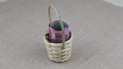 Rolled 10 euro banknotes placed in a small basket rotate on a round table Vídeo Stock 143201382