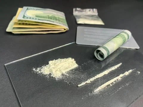 Rolled 100 us dollars, 2 lines of cocaine, plastic bag with illegal drugs and Stock Photos