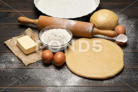Rolled and unbaked Shortcrust pastry dough recipe on wooden background Stock Photos