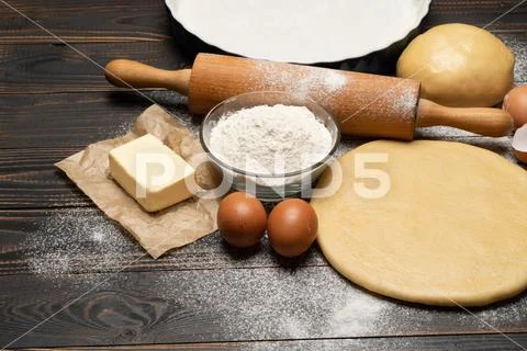 Rolled and unbaked Shortcrust pastry dough recipe on wooden background Stock Photos