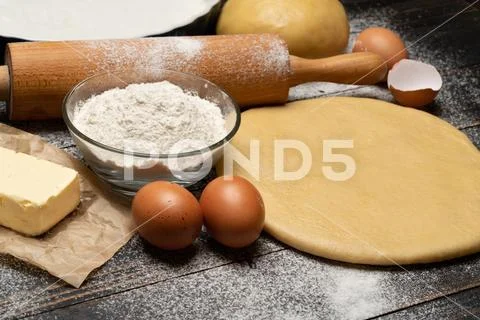 Rolled and unbaked Shortcrust pastry dough recipe on wooden background Stock Photos