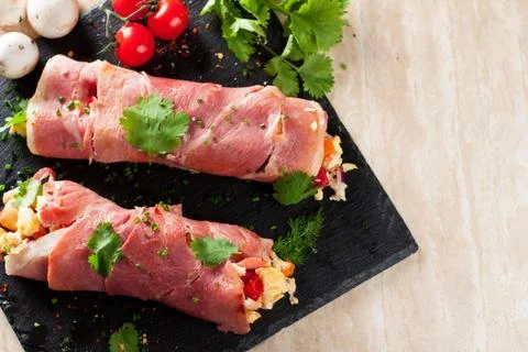 Rolled bacon stuffed with scrambled eggs and vegetables Stock Photos