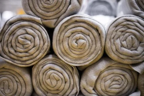 Rolled blankets sorted on top of each other. Rolled blanket in a blanket stor Stock Photos