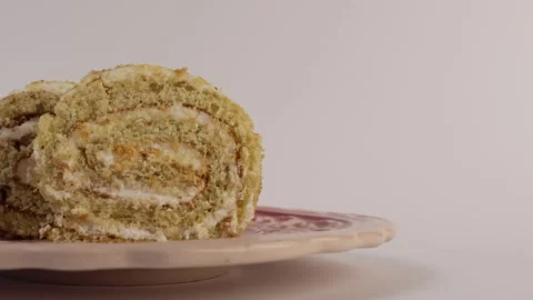 Rolled cake slice showing cream layers and soft sponge texture. Stock Footage 308922850