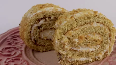 Rolled cake slice showing cream layers and soft sponge texture Stock Footage 308923248