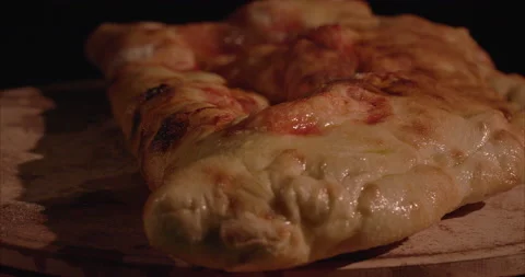 Rolled Calzone Rotating Closeup, Black Background, Oiled Stock Footage 130942373