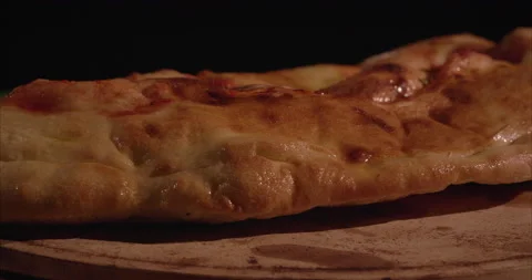 Rolled Calzone Rotating Closeup, Black Background, Oiled Stock Footage 130943451