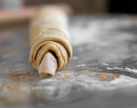 Rolled cinnamon dough on a baking sheet in the oven. Stock Photos
