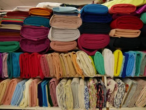 Rolled fabrics. Showcase of multi-colored samples of natural fabrics. Stock Photos