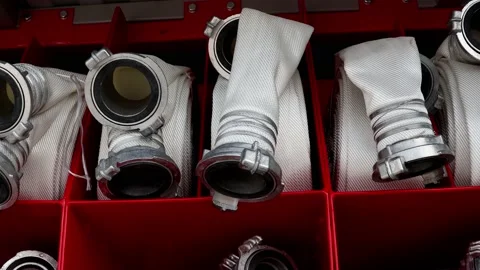 Rolled fire hoses, arranged in rows, in the glove compartment of the fire truck Stock Footage 205437414