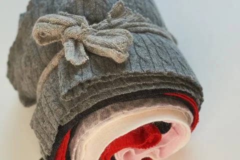 Rolled grey wool and knitted fabric swatches tied with a fabric bow for sewin Stock Photos