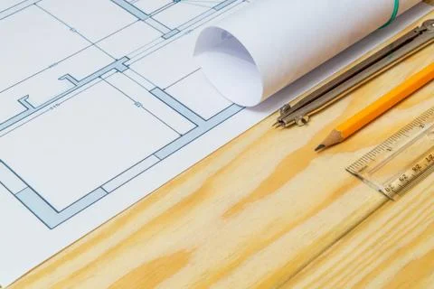 Rolled house diagrams and accessories for drawing lying on construction drawi Stock Photos