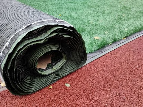 Rolled lawn. Artificial grass in a roll. Improvement of stadiums, sports and Stock Photos