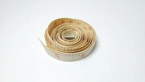 A Rolled Up Measuring Tape on a White Background. Stock Photos