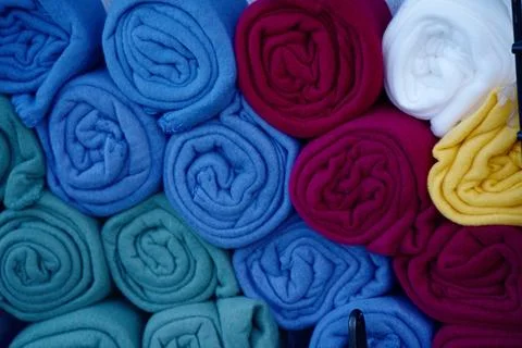 Rolled up microfiber blankets of various colors Stock Photos