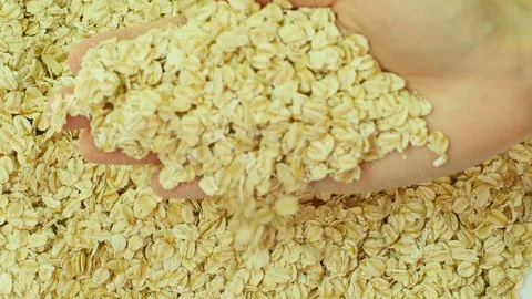 Rolled oat falling from hand. 库存影片 89613477