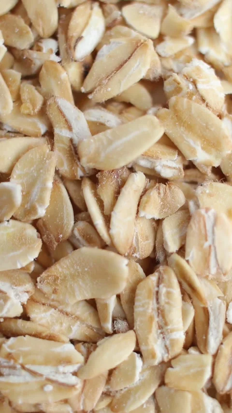Rolled oats grains close up. Front of the camera rotates plate with oats. Stock Footage 269310386