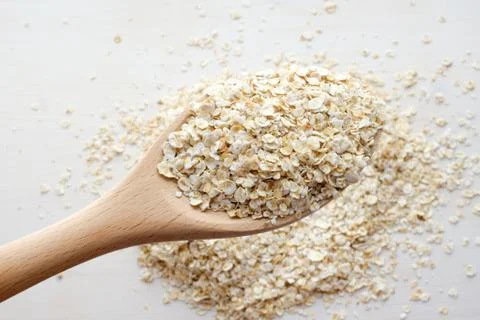 Rolled oats in spoon Stock Photos