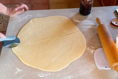 Rolled out dough on bright kitchen counter with rolling pin Stock Photos