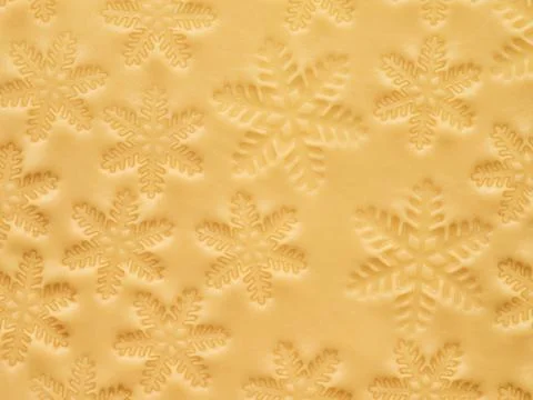 Rolled out dough with cut out Christmas snowflakes shapes texture isolated on Stock Photos