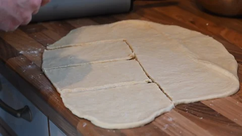 Rolled out dough on the kitchen surface is topped with individual ingredients Stock Footage 129585114