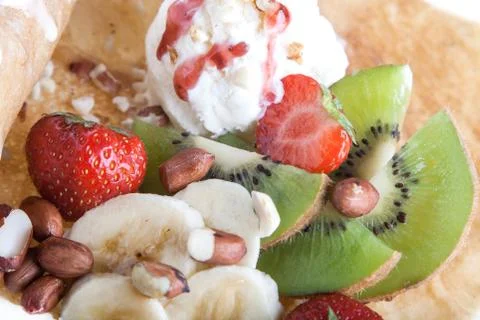 Rolled pancakes with ice-cream and fruits Stock Photos