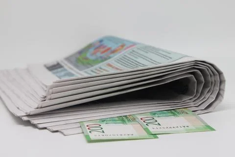 A rolled up stack of newspapers, banknotes stuck between the newspapers, news Stock Photos