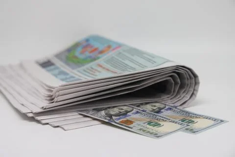 A rolled up stack of newspapers, banknotes stuck between the newspapers, news Stock Photos