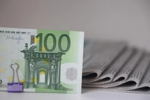 Rolled up stack of newspapers, banknotes stuck between newspapers, news, fake Stock Photos