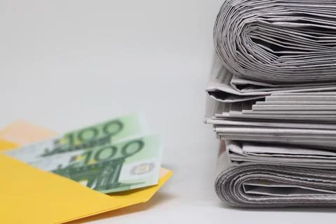 Rolled up stack of newspapers, banknotes stuck between newspapers, news, fa.. Stock Photos