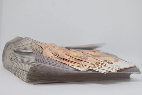 A rolled up stack of newspapers, banknotes stuck between newspapers, news, .. Stock Photos